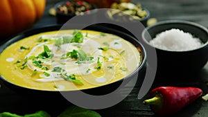 Pumpkin soup in bowl sprinkled with herbs