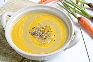 Pumpkin soup with carrot on white table