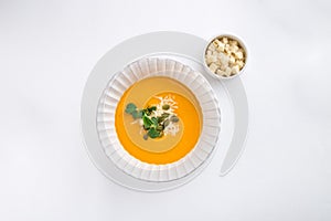 Pumpkin soup with cream and pumpkin seeds and croutons isolated on white background