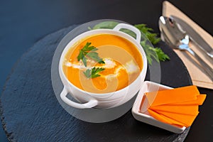 Pumpkin soup garnished with fresh cream and herbs