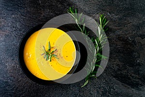 Pumpkin soup with linen napkin on dark background.