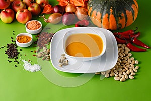 Pumpkin soup with onion and pepper on green shadowless backgroud photo