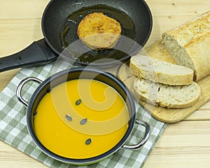 Pumpkin soup, patties in a pan and bread