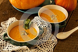 Pumpkin soup served in a ceramic plate, decorated with pumpkin s
