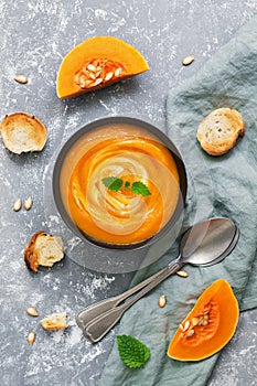 Pumpkin soup is served with toasted toast. Vegetarian soup. Top view.