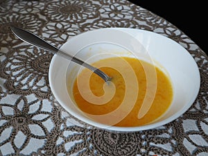 Pumpkin soup. Soup bowl with a spoon on the table