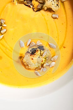 Pumpkin soup in white bowl