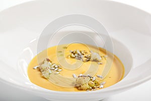 Pumpkin soup in white bowl