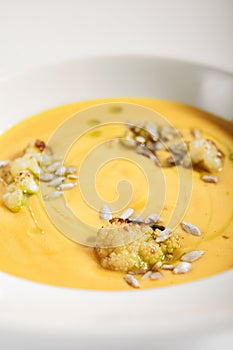 Pumpkin soup in white bowl