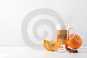 Pumpkin spice latte in a glass mug with cinnamon
