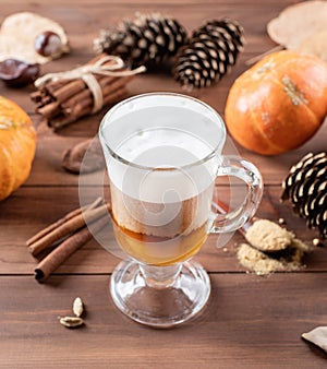 Pumpkin spice latte in a glass mug with cinnamon and ginger