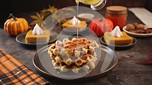 Pumpkin spice whipped latte in glass. Hot autumn drink beverage on checkered tablecloth