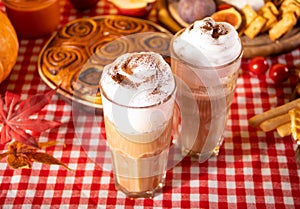 Pumpkin spice whipped latte in two glasses. Hot autumn drink beverage