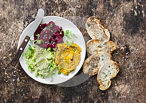 Pumpkin, turmeric, avocado, beetroot hummus with olive oil, sesame seeds and microgreens on a wooden background, top view. Delicio