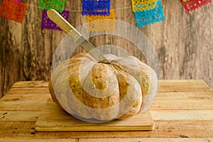 Pumpkin on wooden table. Background with colored papel picado