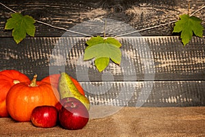 Pumpkins, apples and pear on jute bag .