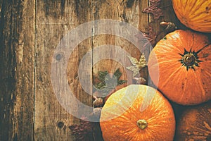 Pumpkins and autumn leaves on wooden background. thanksgiving and halloween concept