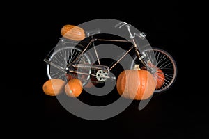 Pumpkins, bicycle and a jute bag on a black background