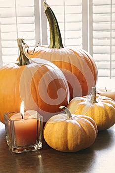 Pumpkins with candle on table