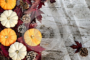 Pumpkins, dried leaves and pine wiht Autumn composition on wood background. Autumn, fall, halloween concept. Flat lay, top view,