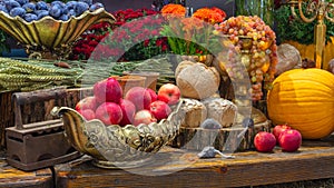 Pumpkins with fruits, bread, vegetables, grapes and flowerson rustic wooden table