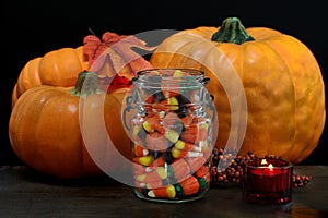 Pumpkins, Halloween candy and a lit candle