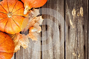 Pumpkins, leaves and berries on old wooden table