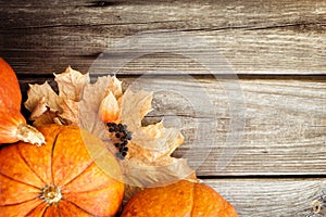 Pumpkins and leaves on old wooden table