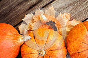 Pumpkins and leaves on old wooden table