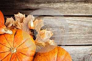 Pumpkins and leaves on old wooden table