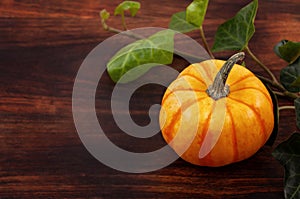 Pumpkins and leaves over wooden background copy space. Template