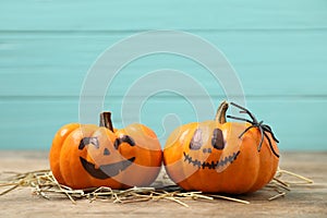 Pumpkins with scary faces on light blue wooden background, space for text. Halloween decor