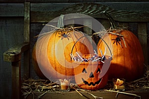 Pumpkins and spiders with candles on bench