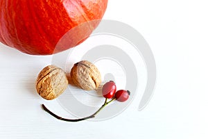 Pumpkins, walnuts, red rose hips, a composition resembling a smiling face