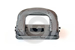 The puncher is metallic gray. Old vintage hole punch on a white background