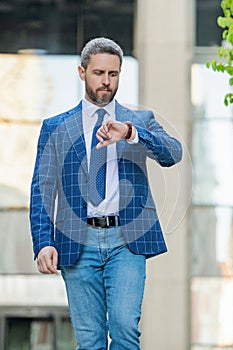 Punctual businessman checking time outdoor. Business deadline. Businessman late for business deadline. Time management photo