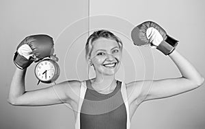 Punctuality and personal efficiency. Time management skills. Battle for self discipline. Woman holding clock boxing
