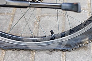 A punctured bicycle wheel on the background of paving slabs