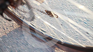 A punctured rear wheel of a bicycle riding on an asphalt road, close-up. Slow motion