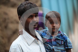 Pune, India - July 16, 2015: A little boy with his poor father w