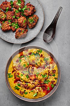 Punjabi Kadhi Pakora in gray bowl on concrete table top. Kadhi Pakoda is indian cuisine curry dish. Asian food and meal