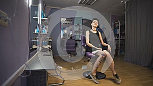 Punk girl with blue hair and tattooed legs in a beauty salon.