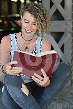Punk woman reading a bible