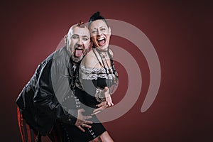 punky style man and woman pose in studio with cheerful expression