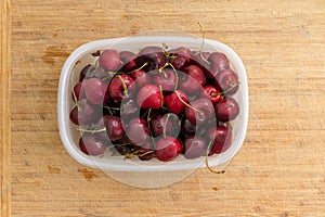 Punnet filled with ripe red summer cherries