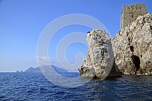 Punta Campanella seen from the sea, in the background the island of Capri and the faraglioni