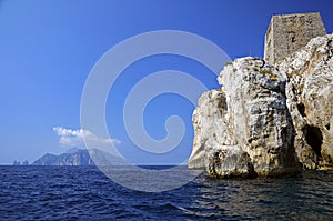 Punta Campanella seen from the sea, in the background the island of Capri and the faraglioni photo