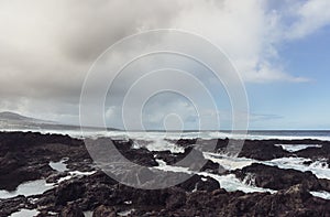 Punta del Hidalgo, Tenerife, Espania - October 27, 2018: Panorama of the rocky beach of Punta de Hidalgo and the waves breaking at photo