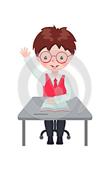 Pupil boy raising hand for an answer at the desk