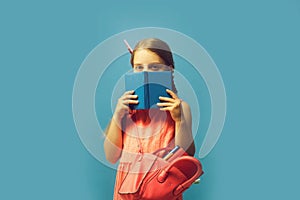 Pupil with braids, isolated on blue background. Back to school